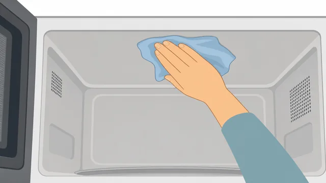 Hand wiping microwave ceiling with damp cloth