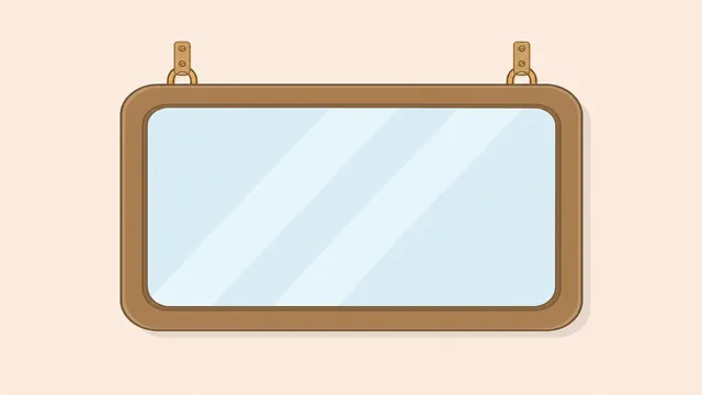 Two people lifting a heavy framed mirror onto two wall hooks
